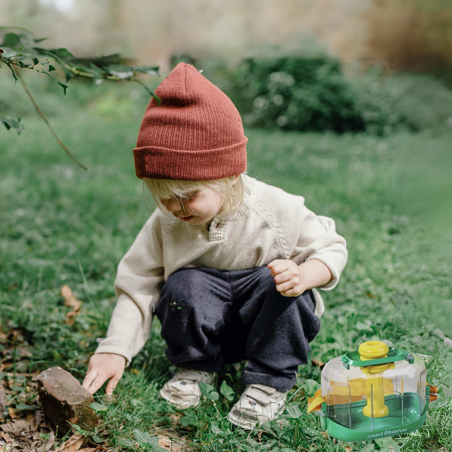 een meisje in het bos met een insectenpotje met vergrotglas