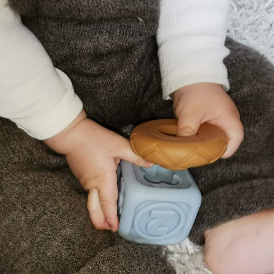 baby hand speelt met een zachte blokken en stapelring met textuur
