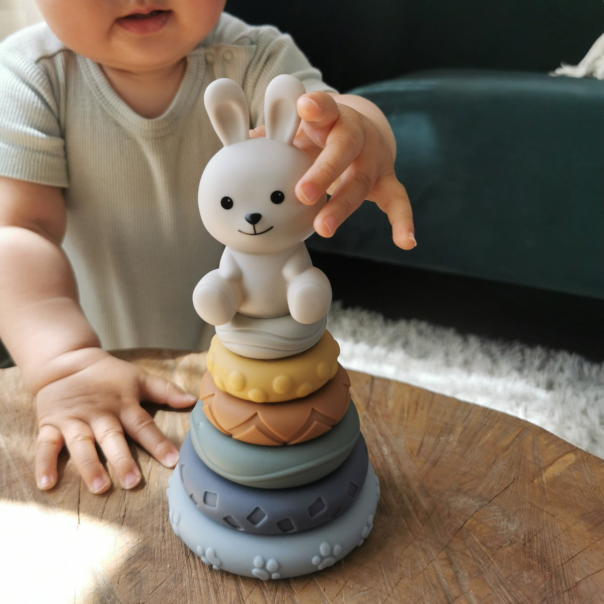 baby stapelringen met een konijn figuur er op. Een baby gaat de figuur paken