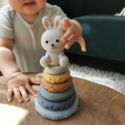 baby stapelringen met een konijn figuur er op. Een baby gaat de figuur paken